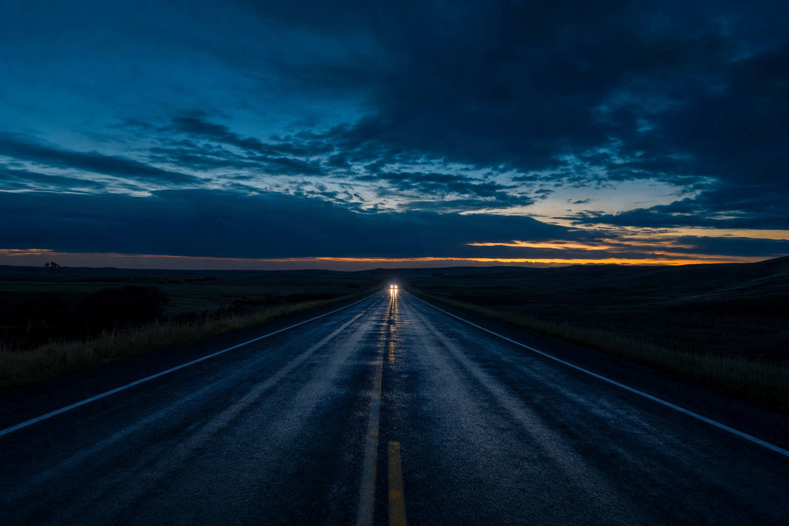 A Heartland highway at night with a gold horizon.